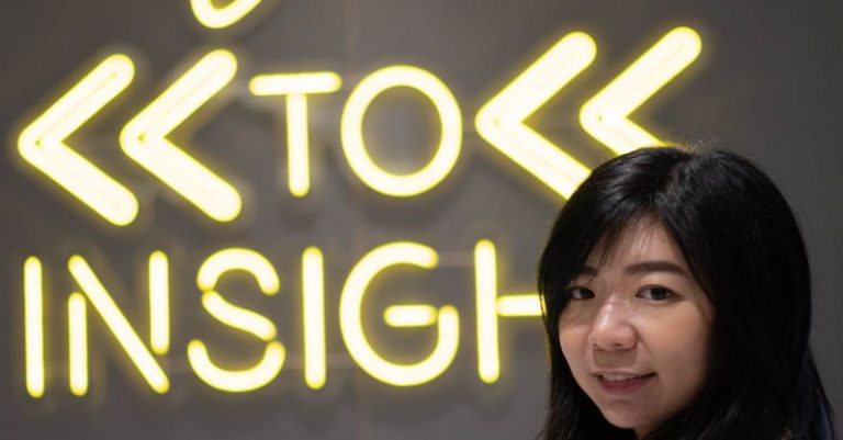 Insights - asian female standing on Welcome sign shop