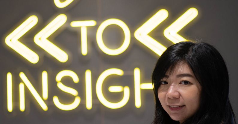 Insights - asian female standing on Welcome sign shop