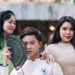 Family-Friendly - Three asian people posing for a photo with a fan