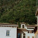 Mountain Retreat - Historic old buildings with archways located on bottom of majestic massive mountain range under blue sky