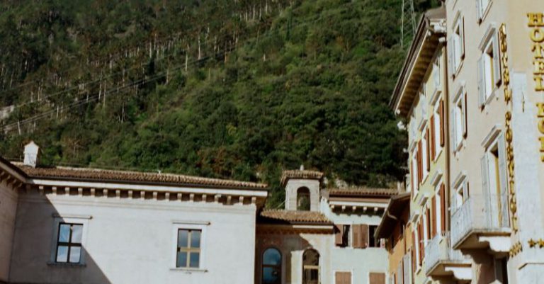 Mountain Retreat - Historic old buildings with archways located on bottom of majestic massive mountain range under blue sky