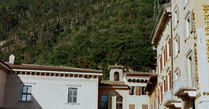 Mountain Retreat - Historic old buildings with archways located on bottom of majestic massive mountain range under blue sky