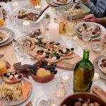 Family Reunions - From above crop people enjoying festive dinner with snacks at garden table with candles burning