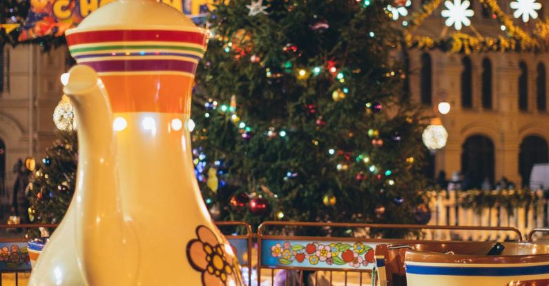 Large-Scale Event - Merry go round with large colorful traditional Russian teapot and cups in city park decorated in New Year style in evening