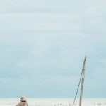 Locals - Two Men Dragging Wooden Boat on Sea Shore