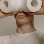 Safe Stay - Man in White Crew Neck Shirt Holding 2 White Tissue Rolls