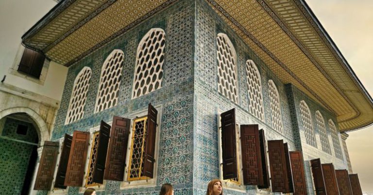Excursions - People Standing in Front of Brown and White Building