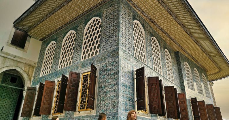 Excursions - People Standing in Front of Brown and White Building
