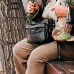 Romantic Getaway - An old man sitting on a bench holding a bunch of red roses