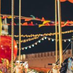 Themed Events - Festive merry go round with carnival horses on Red Square against blurred Kremlin during New Year holidays in evening